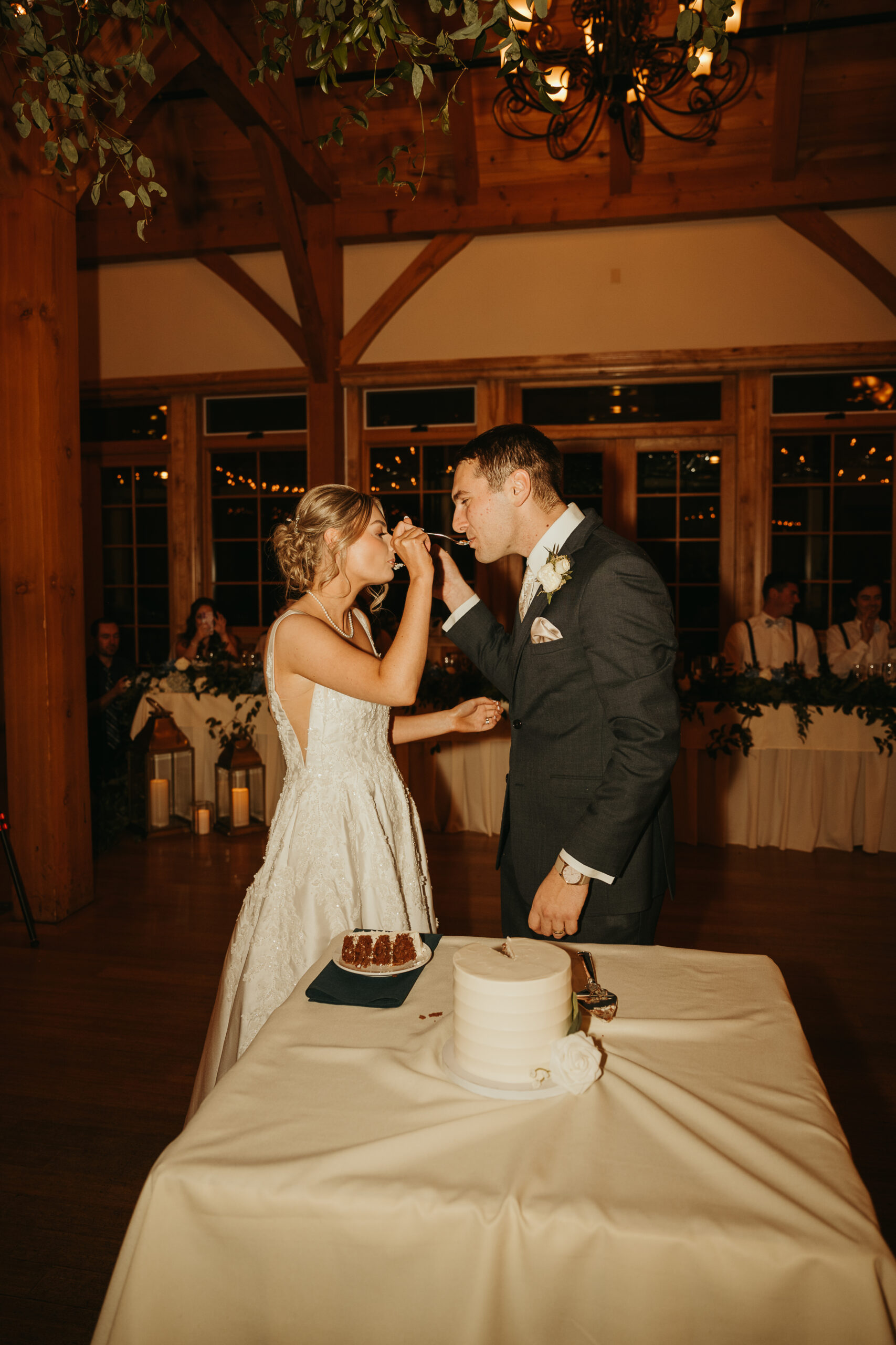 bride and groom cutting cake at The Red Barn at Outlook Farm